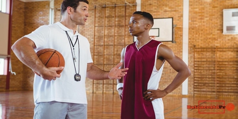Basketball coach giving instructions to one of his basketball team players